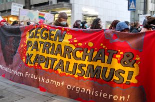 Demoteilnehmer tragen ein Transparent mit Aufschrift "Gegen Patriachat & Kapitalismus"